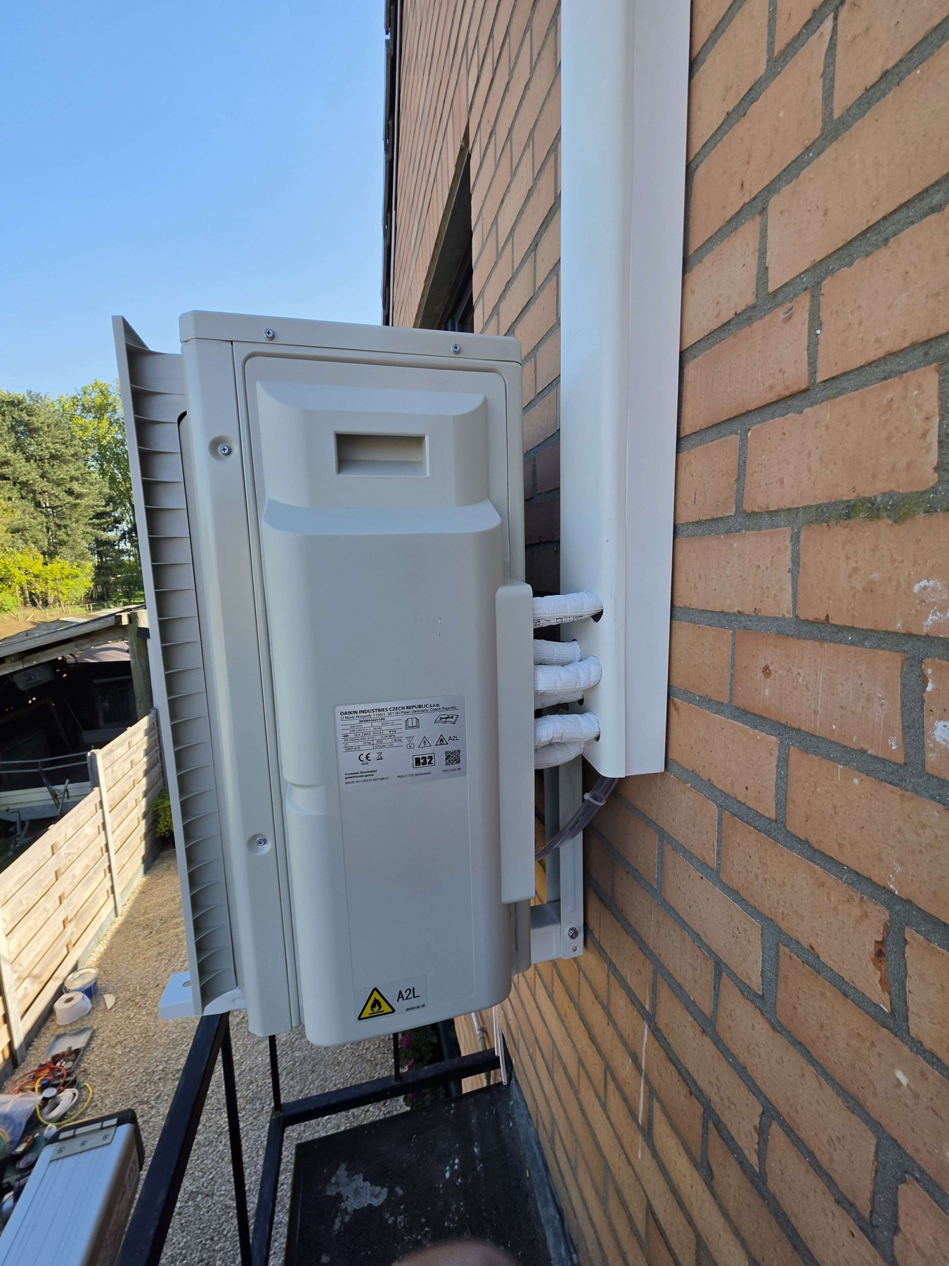 Zijaansluitingen en afgewerkte leidingen bij de Daikin-buitenunit